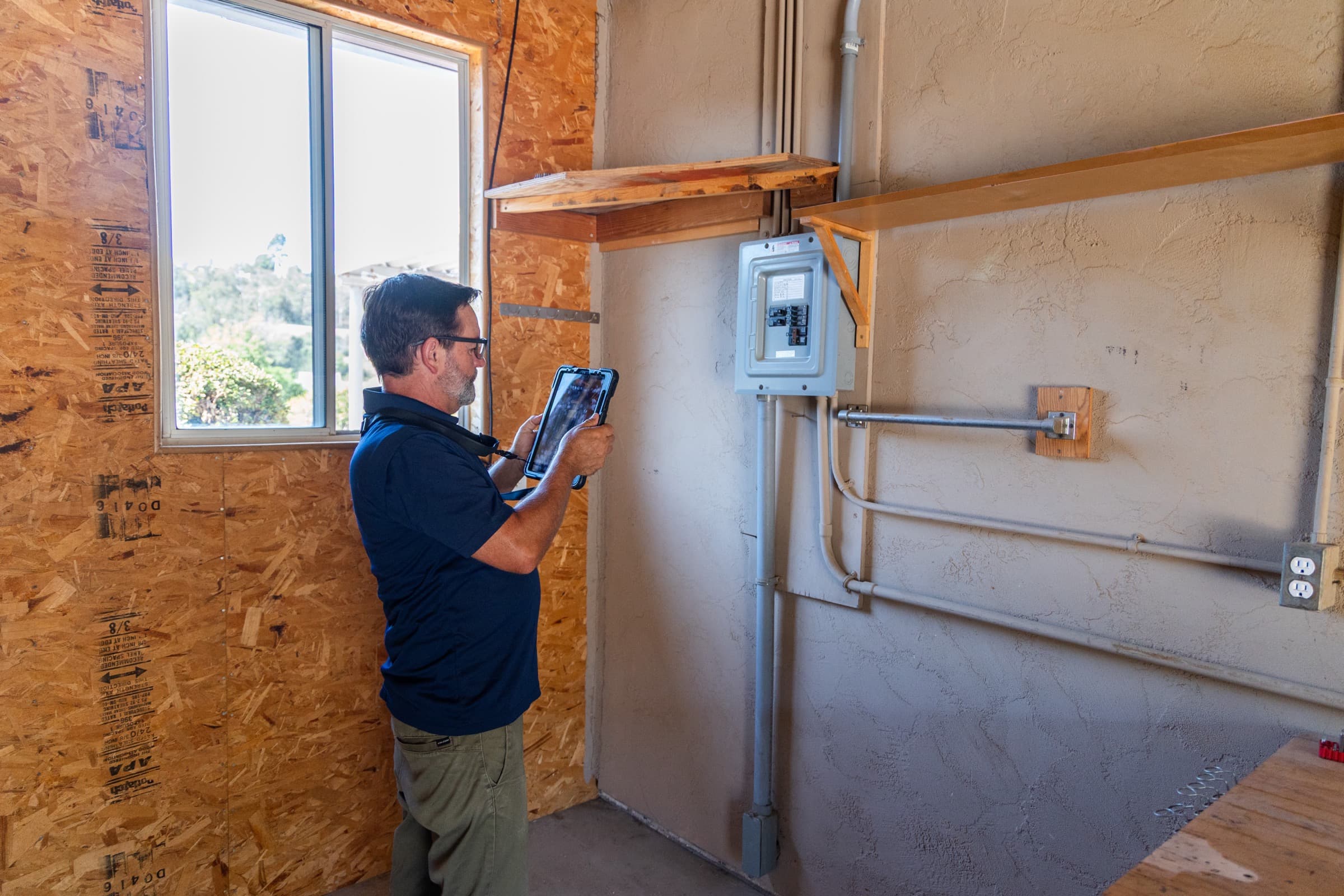 Inspector evaluating an electrical panel — always worth a professional look in rural outbuildings